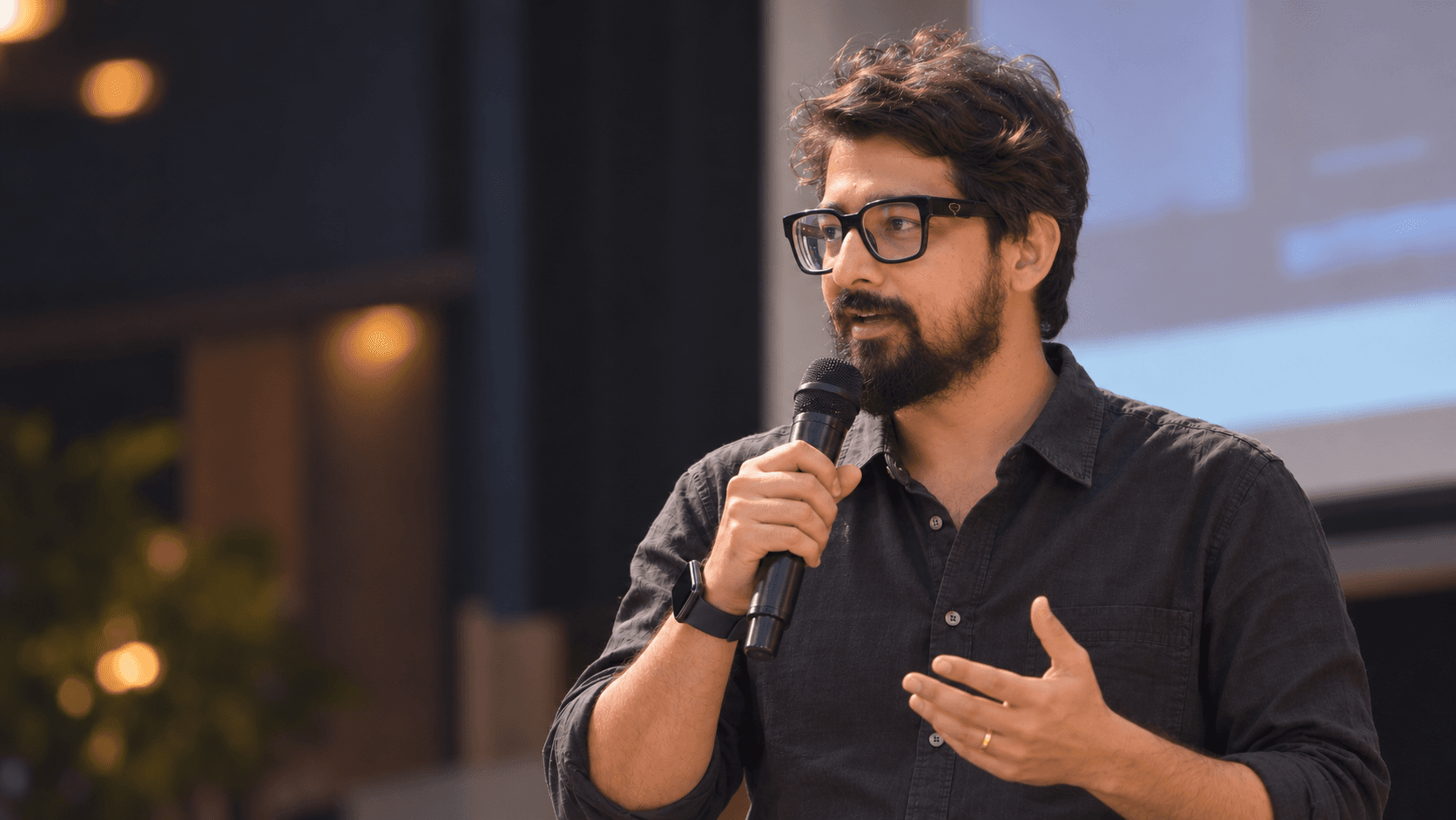 Tuhin Patra speaking into a microphone at an event